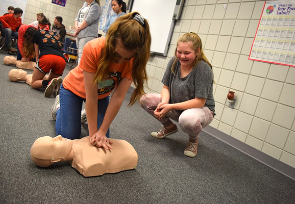 Girls learning CPR in school